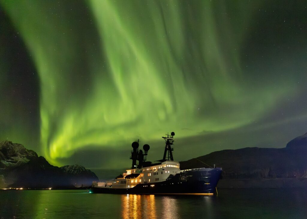 Expedition yacht at anchor under the northern lights in Norway